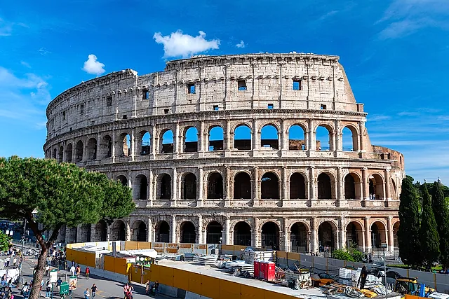 El Coliseo visto desde fuera en un día soleado, con sus tres órdenes de arcos contra un cielo azul